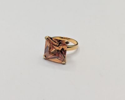 a close up of a ring with a pink stone in it