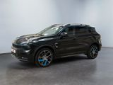 Le SUV noir est garé dans une pièce aux murs blancs.