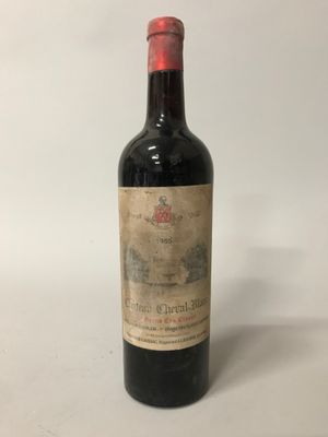 une vieille bouteille de vin posée sur une table blanche