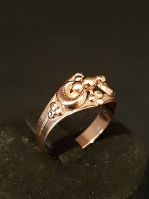 a gold ring with a skull and crossbone design on it