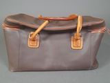 a brown and tan bag with handles on a gray surface