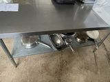 a stainless steel table with pots and pans on it