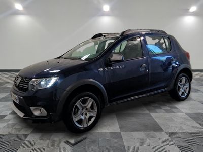 La Dacia bleue est garée dans une pièce au sol carrelé en damier