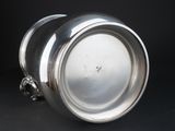 an antique silver plate with a handle on a black background