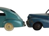 deux voitures jouets assises l'une à côté de l'autre sur une surface blanche