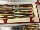 six knives in a case with a knife on top of it