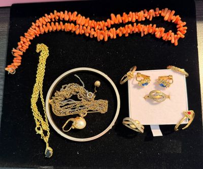 a necklace, bracelet, ring, and other jewelry displayed on a table
