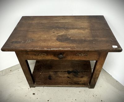 an old wooden table with a drawer underneath it on a cement floor