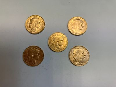 quatre types différents de pièces d'or sur une surface blanche
