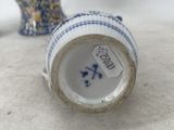 a small blue and white vase sitting next to a small blue and white vase