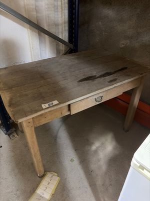 a wooden desk with a drawer underneath it in a garage