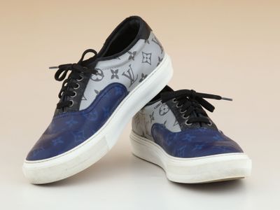 une paire de chaussures bleues et blanches ornées d'étoiles sur un fond blanc