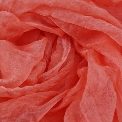 un gros plan sur une écharpe rose ornée d'une très longue frange