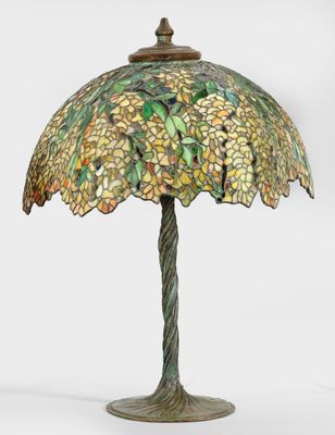 une lampe de table surmontée d'un abat-jour en verre