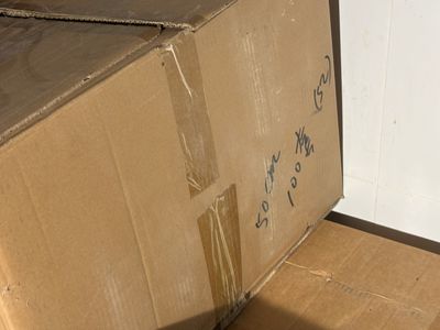 a cardboard box sitting on the floor next to a wall