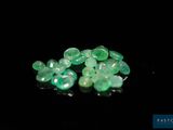 a close up of a bunch of green stones on a black surface