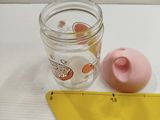 a jar of water next to a measuring tape on a table