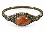 a close up of a bracelet with a stone in the center