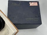 a box with a watch inside of it on a white surface