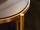 a gold table with a black top next to a couch