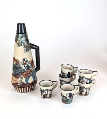 a pitcher and cups sitting next to each other on a table