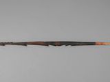 an old wooden stick with a wooden handle on a gray surface
