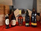 several bottles of wine are sitting on a table with a red cloth