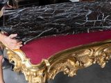a man that is standing next to a table with a marble top