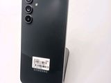 the back of a black cell phone with a barcode on it