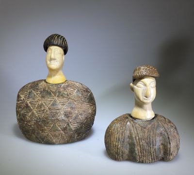 two figurines of a man and a woman sitting next to each other