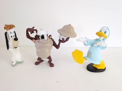 three figurines of cartoon characters on a white surface