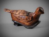 an old wooden bird sitting on top of a wooden box