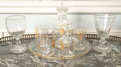 des bouteilles et des verres posés sur un plateau, sur une table devant une fenêtre