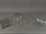 a lot of forks and spoons sitting on a table