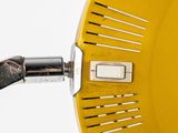 a close up of a yellow colander with a metal handle