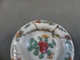 a small plate with a rose on it on a table