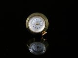 une horloge dorée posée sur une surface noire