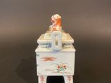 a small white box with a bird on top of it