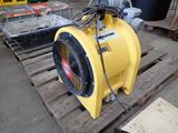 a yellow blower sitting on a pallet in a warehouse