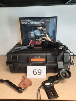 une boîte contenant un appareil photo et quelques autres objets, posée sur une table