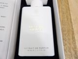 a bottle of perfume in a white box on a table