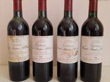 three bottles of red wine are lined up on a table