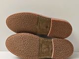 pair of brown slippers on a white surface with a white background