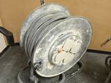 a large reel on the ground next to a pair of shoes