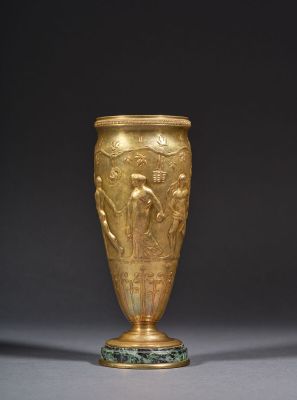 une image représentant un vase en or posé sur une table