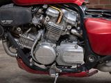 a red motorcycle parked in front of a brick wall