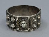a close up of a silver bracelet on a gray surface