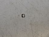 a close up of a metal bowl with a hole in it