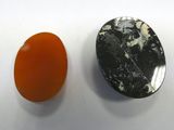 an orange and black stone next to a black and white stone