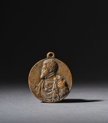 a bronze medal depicting a woman holding a child